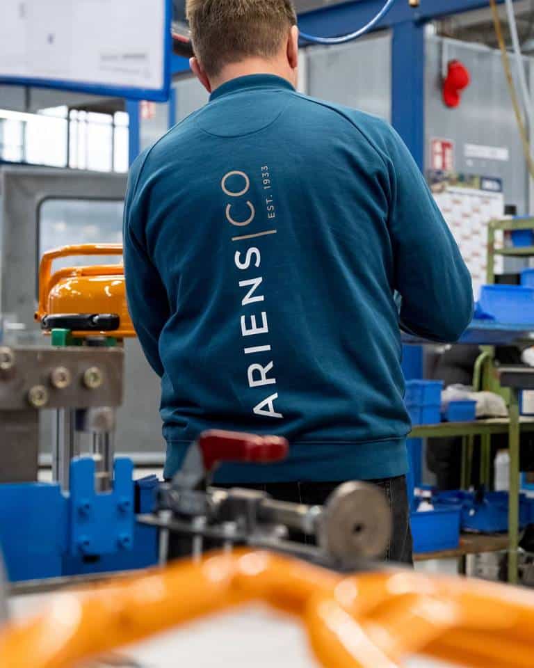 Factory worker of AriensCo EMEAA wearing their new turquise work wear inside their factory in Bühlertann, Germany